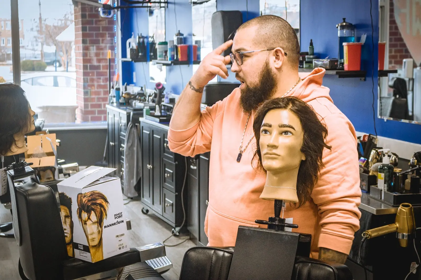 A Hair Wizards educator teaching with a mannequin head in the shop